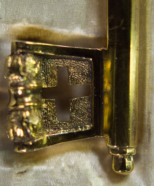 Nahaufnahme des Schlüsselbarts eines preußischen Kammerherrenschlüssels mit kreuzartiger Öffnung und floraler Verzierung.