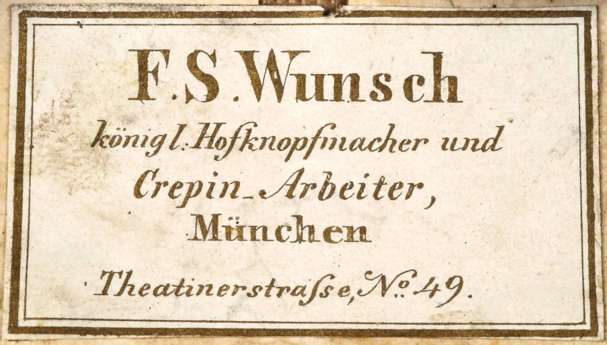 Klebeschild der Firma Friedrich Seraph Wunsch auf der Rückseite eines Portepees unter der Regierung von König Maximilian II. von Bayern angebracht. Es kommen auch Klebeschilder der Firma Bornhauser, Militär Effecten Fabrik aus München, ehem. Pilotystrasse 11a vor.
